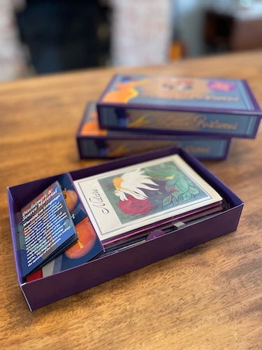 A purple game box with cards and booklets displaying unique and modern illustrations of old wives tales and folklore with Victorian and Art Deco elements. Perfect for gifting.