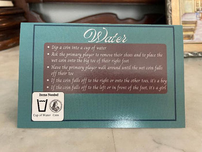 A card from a baby shower game displaying instructions and items needed to conduct gameplay action.